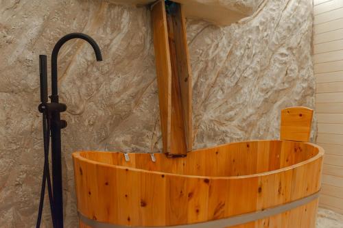a wooden tub in a room with a stone wall at La Trinità Private Spa in Corciano