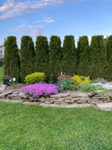 a garden with colorful flowers and a stone path at Apartment Skurčák in Zuberec