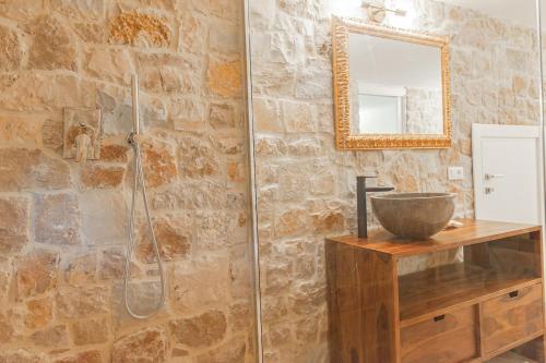 a bathroom with a shower with a sink and a mirror at La Trinità Private Spa in Corciano