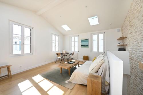 une chambre blanche avec un lit et une table dans l'établissement 504 La suite caractère et élégance, à Ars-en-Ré