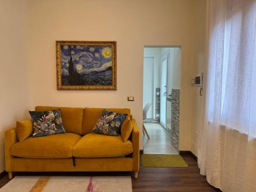 a living room with a couch and a painting on the wall at IRIDE HOME - Wellness & Relax in Bergamo