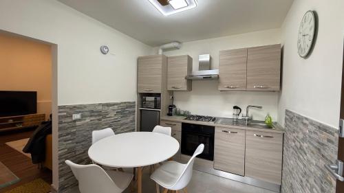 a kitchen with a white table and white chairs at IRIDE HOME - Wellness & Relax in Bergamo