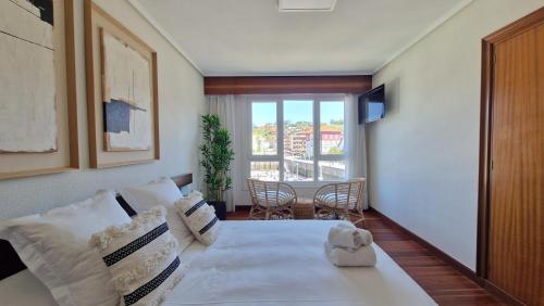 a living room with a large white bed and a window at VISTAS MAR Y PUERTO Plentzia - 200m2 y Parking in Plentzia