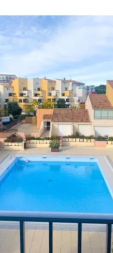 - une grande piscine bleue au-dessus d'un bâtiment dans l'établissement Cap d'Agde F3 belle vue port avec Garage Piscine Climatisation, au Cap d'Agde