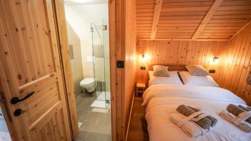 two beds in a room with a shower at Glamping Avantura- a natural getaway by the Kolpa River in Kostel