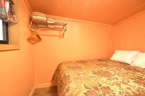 une petite chambre avec un lit et un porte-serviettes dans l'établissement Log Cabin Getaway in the Mountains for Two near Maggie Valley, North Carolina, à Cherokee