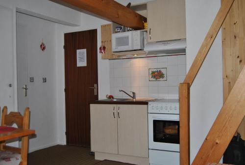 une petite cuisine avec un évier et une cuisinière dans l'établissement Appartement Balcon piscine tennis vue Montagne, à Saint-Gervais-les-Bains