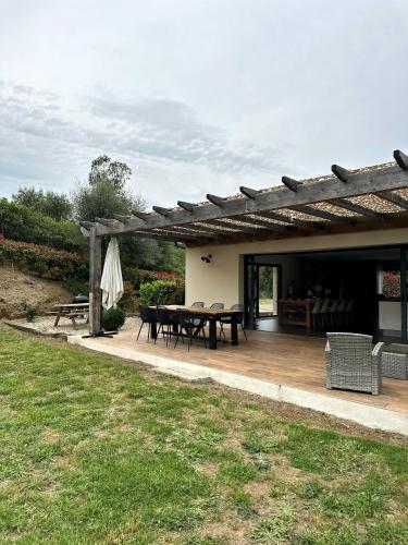 une terrasse avec une table de pique-nique et une pergola dans l'établissement Villa U Sole, à Oletta