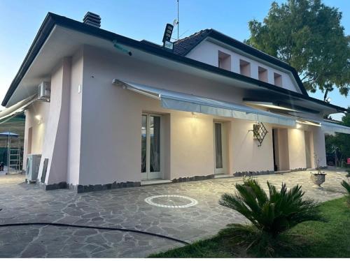 a white house with a courtyard in front of it at Villa Ninfea Lux Tavullia, Jacuzzi, Garden, Wifi, Ac in Tavullia