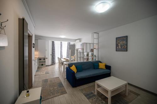 a living room with a blue couch and a table at Sery Apartment Resort Alz in Mamaia Sat/Năvodari