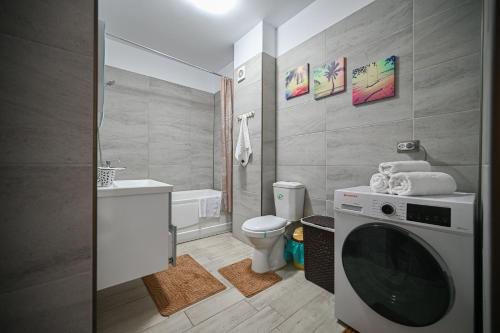 a bathroom with a toilet and a washing machine at Sery Apartment Resort Alz in Mamaia Sat/Năvodari