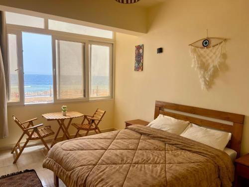 a bedroom with a bed and a table with chairs at Tree House Hotel Dahab in Dahab