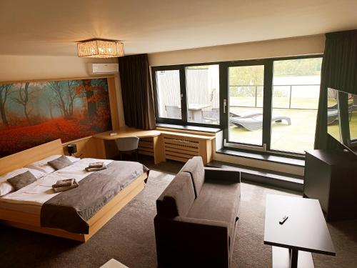 a bedroom with a bed and a desk and a couch at Hotel Kras in Jedovnice