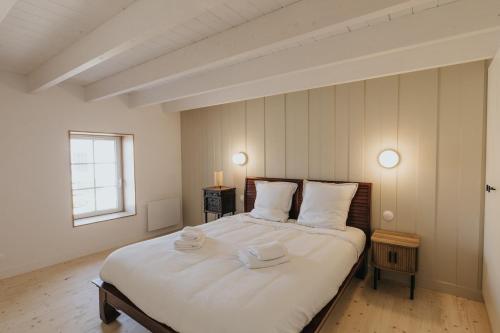 une chambre avec un grand lit avec deux serviettes dessus dans l'établissement Maison lumineuse moderne entièrement renovée, à Saint-Renan