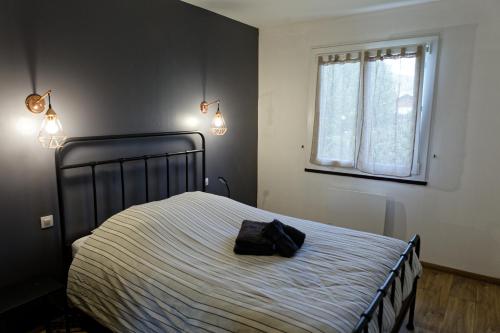 a bedroom with a bed with a bag on it at Maison RoMa, se ressourcer proche de Gerardmer et La Bresse in Vagney