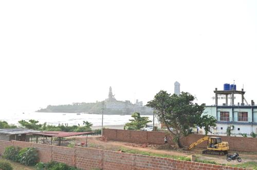 a view of the ocean and a building with a tractor at Evengel Beach Home Stay in Māvalli