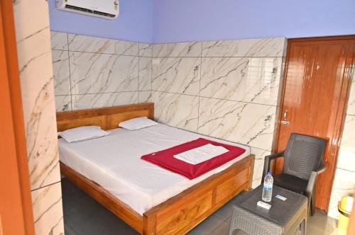 a bedroom with a bed and a table and a chair at Evengel Beach Home Stay in Māvalli
