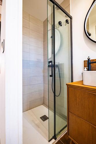 une douche avec une porte vitrée dans une salle de bain dans l'établissement Duplex Canet proche de la plage, à Canet