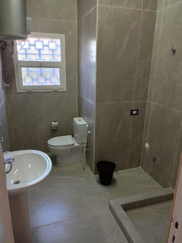 a bathroom with a toilet and a shower and a sink at استمتع بالصيف في فيلا الأحلام مكيفة بالكامل وبخطوات من البحر in Dawwār Ibrāhīm Abū Shunaywīr