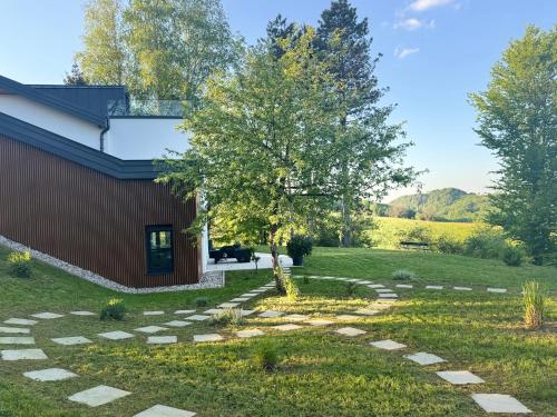 a garden with a tree and a stone walkway at Kuća za odmor Šumska vila in Duga Resa