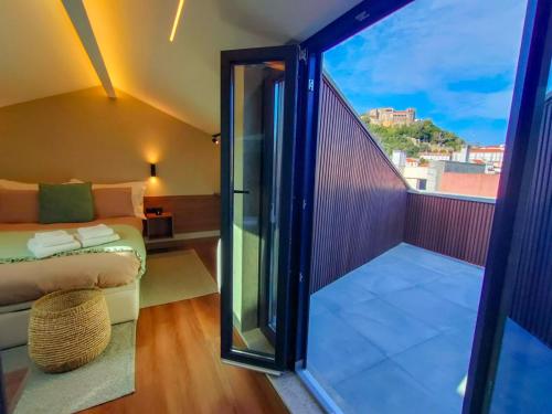 a room with a balcony with a couch and a glass door at Castle Studios in Leiria