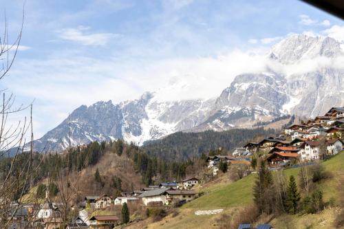 a village on a hill with mountains in the background at Bergvilla Vivaldi - Happy Mountain Vibes in Mühlbach am Hochkönig