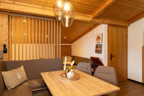a living room with a table and a couch at Bergvilla Vivaldi - Happy Mountain Vibes in Mühlbach am Hochkönig