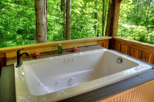 eine große Badewanne in einem Raum mit Bäumen in der Unterkunft Tiny House for Two with Outdoor Tub near Great Smoky Mountains in Cherokee, North Carolina in Cherokee