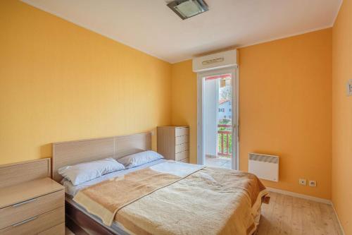 une chambre avec un grand lit et une fenêtre dans l'établissement Biantenia B23 Appartement avec balcon et parking sur les hauteurs, à Hendaye