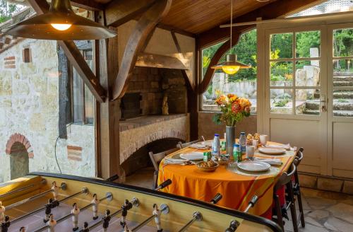 a dining room with a table and a fireplace at Lacoume Saint Jacques in Auch