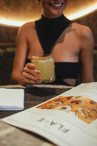 a woman sitting at a table with a drink at ibis Zürich City West in Zürich