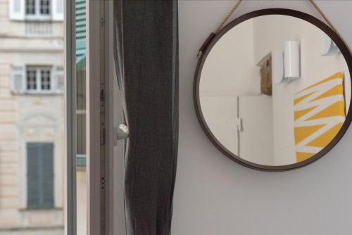 un espejo colgado en una pared junto a una ventana en Designer apartment in the center of Genoa, en Génova