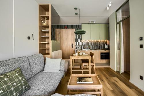 a living room with a couch and a table at TatryTop Słoneczna Rezydencja Jacuzzi & Sauna in Białka Tatrzanska