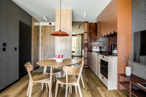 a kitchen and dining room with a wooden table and chairs at TatryTop Słoneczna Rezydencja Jacuzzi & Sauna in Białka Tatrzanska