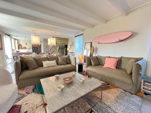 a living room with two couches and a table at Maison de famille Ty Pampa in Sibiril