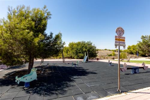a park with a playground with trees and a sign at Descanso en la Costa in Dehesa de Campoamor