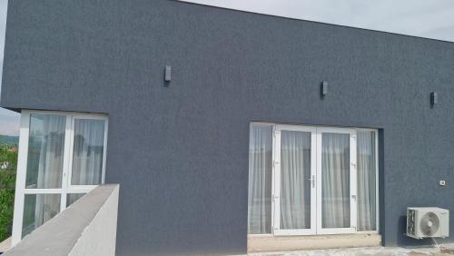a blue building with white doors on the side of it at Casa Damian DROBETA in Drobeta-Turnu Severin
