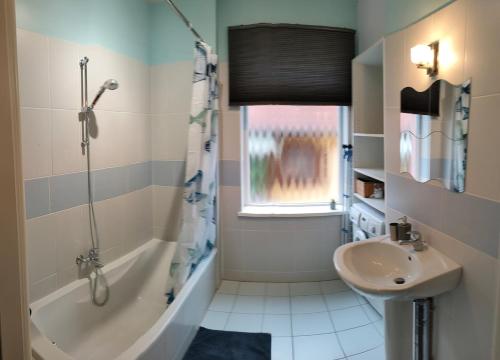 une salle de bain avec une baignoire, un lavabo et une douche dans l'établissement Large apartment parking, à Epfig