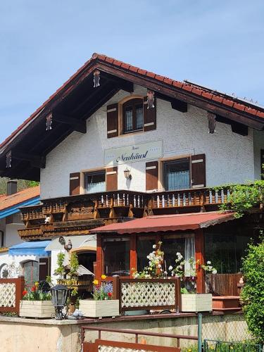 a building with a balcony with flowers on it at Haus Neuhäusl inkl. Chiemgaukarte in Ruhpolding