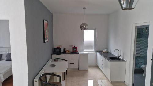 a white bathroom with a sink and a bed at Casa Damian DROBETA in Drobeta-Turnu Severin