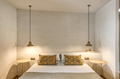 a bedroom with a white bed and two tables at Les Hamaques Hotel in Viladamat