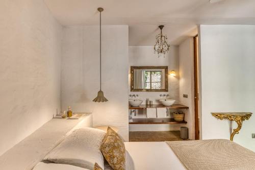 a bedroom with a bed and a bathroom with a sink at Les Hamaques Hotel in Viladamat