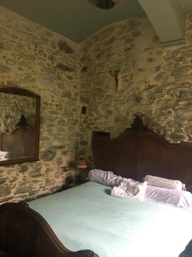 une chambre avec un lit dans un mur de pierre dans l'établissement beautiful arched stone apartment 1 bd, à Mons