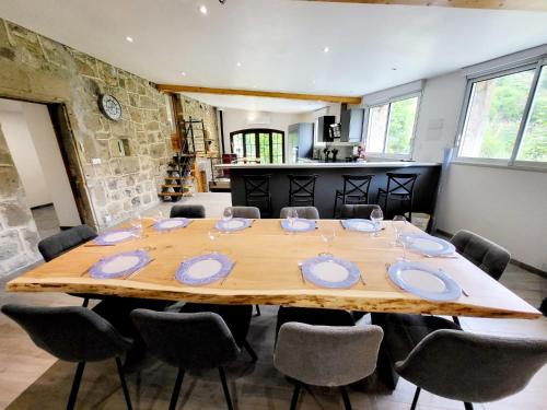 une salle à manger avec une grande table et des chaises en bois dans l'établissement Maison Ardéchoise Jacuzzi Piscine Pétanque, à Saint-Joseph-des-Bancs