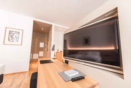 a large flat screen tv on a wall in a living room at Göttfried - essen trinken schlafen in Linz