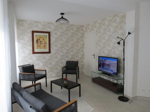 a living room with a couch and a television at Home SAINT-MAURILLE in Angers