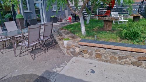 a patio with a table and chairs and a bench at Casa Damian DROBETA in Drobeta-Turnu Severin