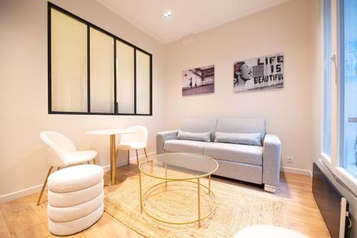 un salon avec un canapé et une table dans l'établissement 1 BR Saint Germain Luxembourg Garden, à Paris