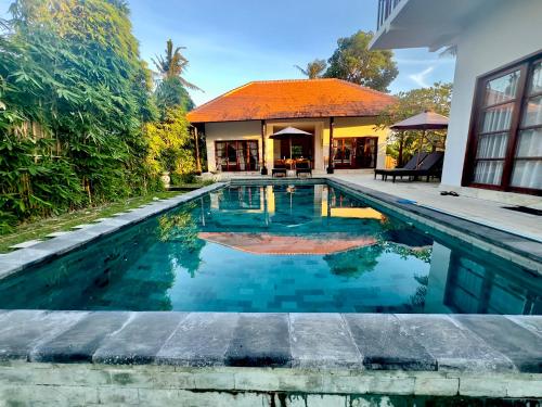 a swimming pool in front of a house at Villa Light - Amed Bali in Amed