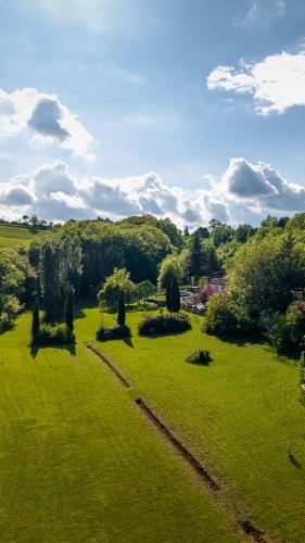 a field of green grass with trees in the distance at Lacoume Saint Jacques in Auch